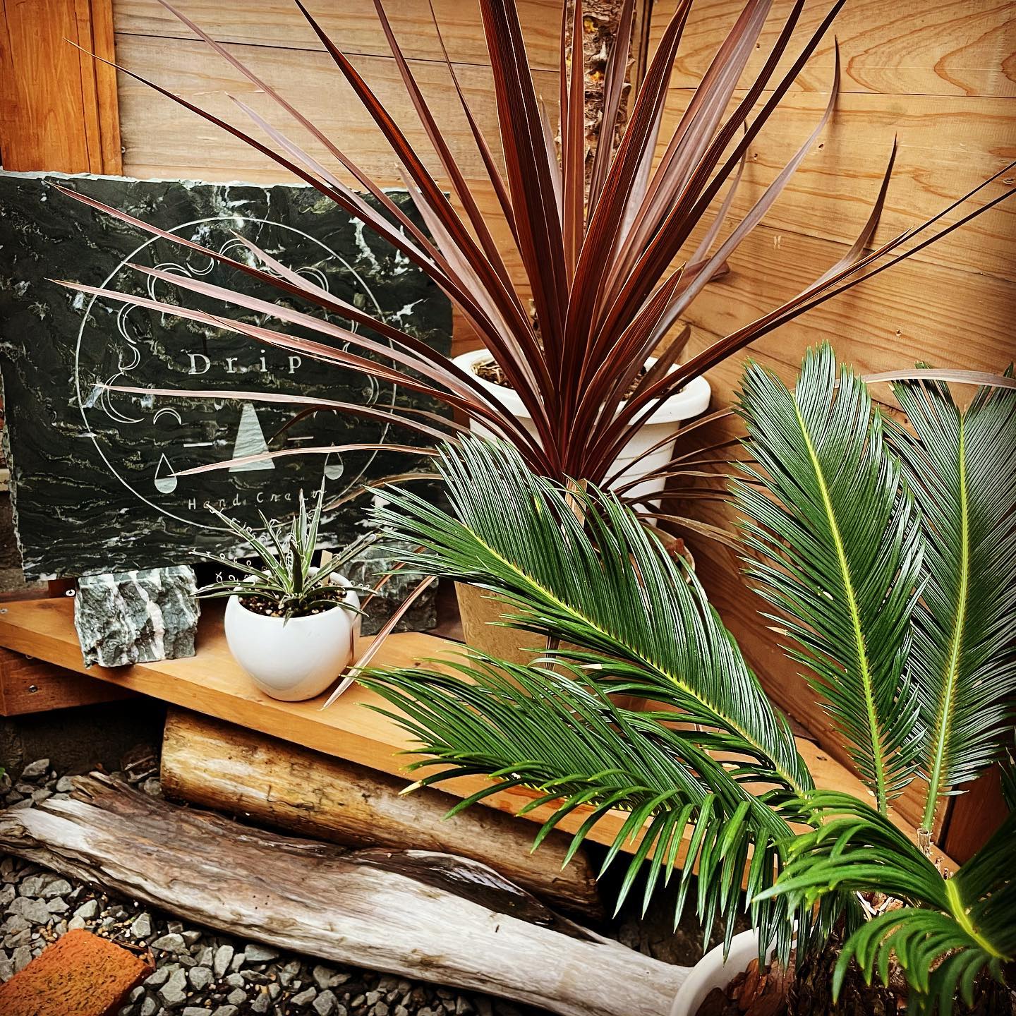 植物に囲まれたDrip Handcraftの工房看板